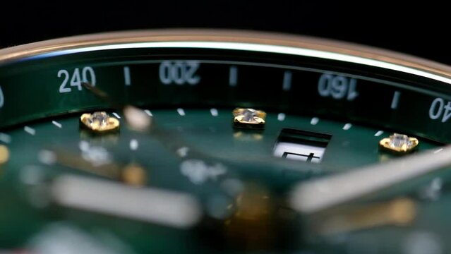 Close Up Of Stylish Luxury Man Wrist Watch With Moving Hand And Multiple Dials. Men's chronograph watch in metal with sapphire crystal. closeup view of rotating watch, running second arrow. green dial