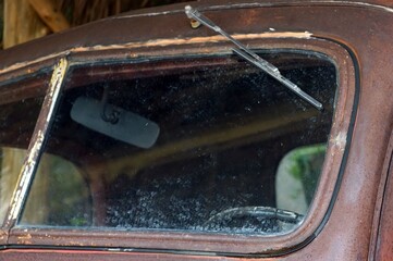 A old classic car with dirty glass and broken windshield, detail of old car.