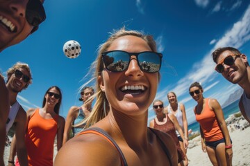 Group of friends - women and men - playing beach volleyball, one in front doing tricks to the ball