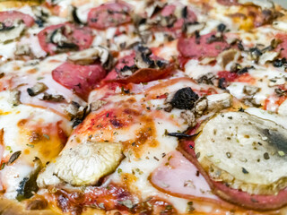 Big and tasty pizza on fat crust with a lot of toppings like pepperoni, champignons, sauce, cheese and aromatic spices