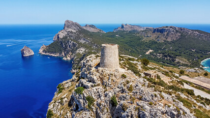 Aerial view of the Albercutx watchtower, an ancient fortified building sitting at the top of a...