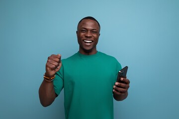 young handsome american guy dressed in a basic t-shirt uses a smartphone