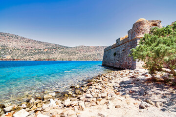 View of the island of Spinalonga with calm sea.