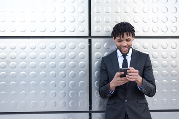 businessman using smartphone at street silver wall