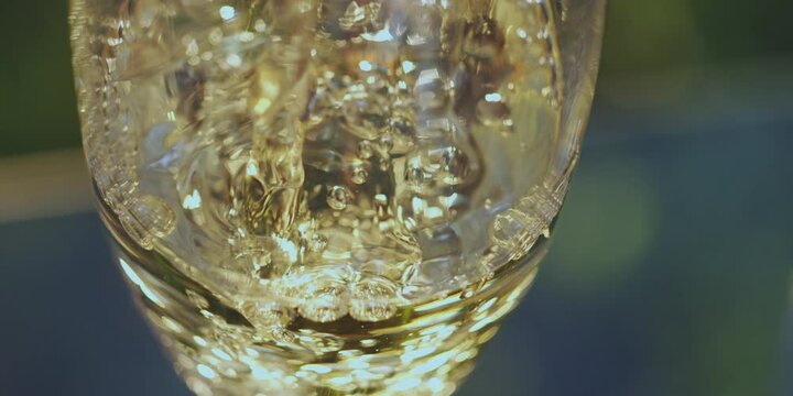 Extreme close-up view of pouring golden champagne with a lot of bubbles into the glass