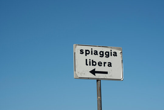 Sign with the inscription "Free Beach", with the blue sky in the background
