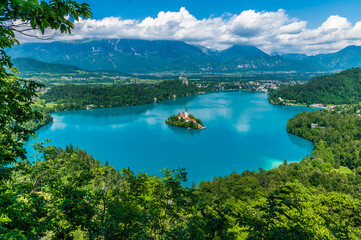 A tree framed view from the Mala Osojnica viewpoint over Lake Bled, Slovenia in summertime