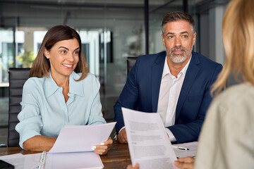 Group of diverse partners mature Latin business man and European business women discussing project...