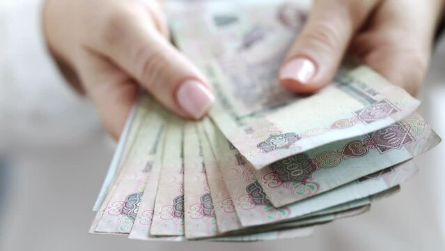Woman Counting AED Dirhams in hands, closeup