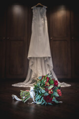 The brides bouquet hanging in front of the wedding dress