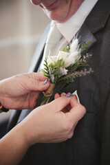 A grooms button hole flower being fitted