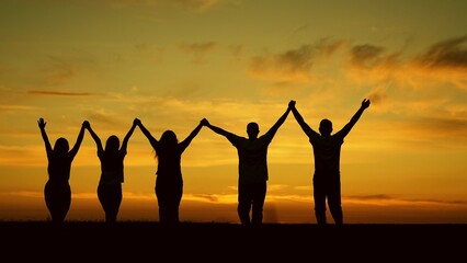 Group of business people outdoors raise their hands to sky. Team of people look at their future together at sunset, park. Human resources. Community of people joint prayer. Unity of group of people