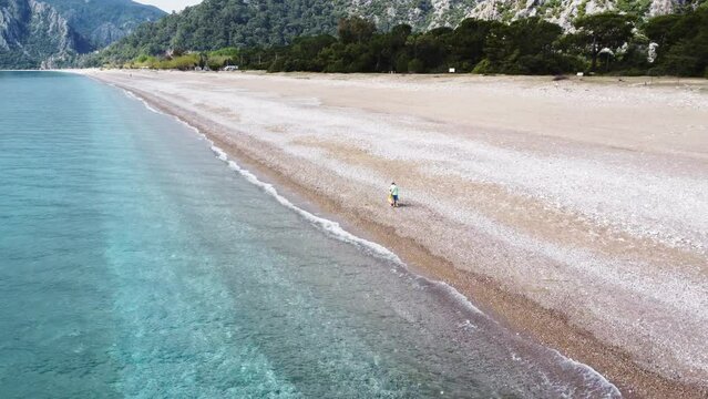 Mother and son on the empty beach enjoing beautiful Mediterranean sea landscape. Aerial drone view. Türkiye