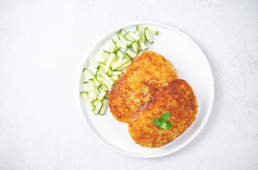 Fresh prepared schnitzel in a plate with fresh cucumber slices