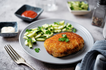 Fresh prepared schnitzel in a plate with fresh cucumber slices