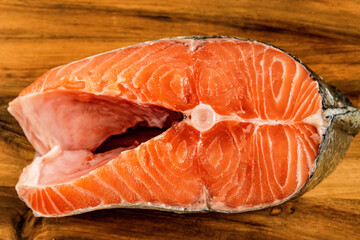 Raw, fresh salmon steak with a skin on a slate board