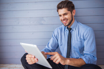 Handsome young businessman with gadget