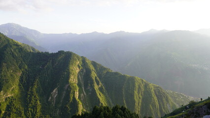 Sunlit mountainous valley with verdant slopes in Neelum Valley, AJK, Jammu Kashmir