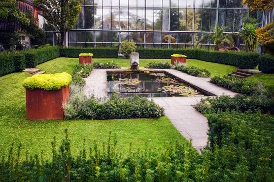 Peat moss in weathering steel (COR-TEN) boxes (several) and pond in cenrtre with water lilies in Augsburg