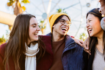 Group of young happy friends enjoying winter vacation outdoors. Millennial student people laughing...