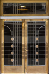 art deco entrance double doors with geometric design in chrome and brass metal