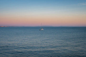 Fototapeta premium Aerial view of a sailboat in the sea at sunset in Cascais, Portugal 