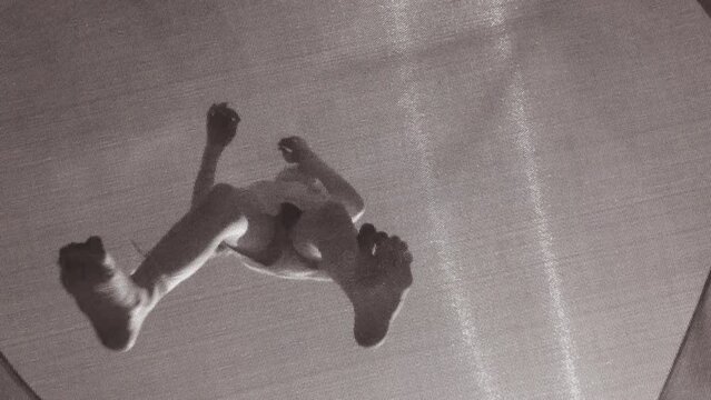 Bottom up view on girl bouncing on a trampoline. Slow motion full HD video child jumping on the trampoline