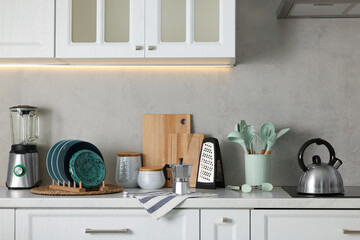 Set of different utensils and dishes on countertop in kitchen