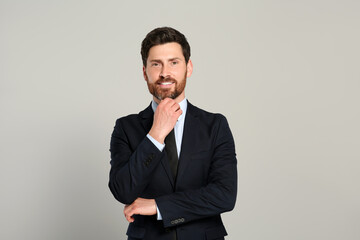 Handsome real estate agent in nice suit on grey background