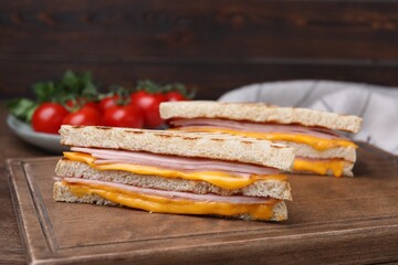 Delicious grilled sandwiches with ham and cheese on table, closeup