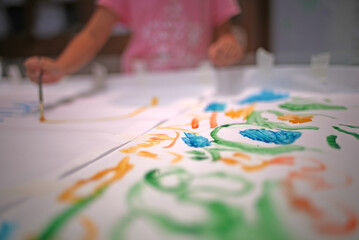 out of focus image of a girl painting with a brush.