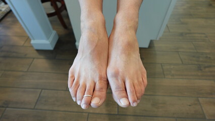 Man's feet side by side with toe ring in the home