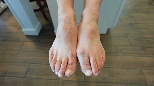 Man's feet side by side with toe ring in the home