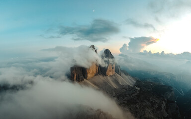 Majestic Tre Cime di Lavaredo being revealed in a dramatic light with low clouds.