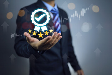 A businessman holds a five star quality assurance mark in his hand, indicating that the quality of...