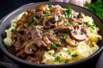 Creamy beef stroganoff with tender meat, caramelized onions, and earthy mushrooms served over fluffy mashed potatoes in a close-up, homemade dinner.