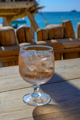 Summer time in Provence, glass of rose wine with ice cubes on bar terrace Pampelonne sandy beach near Saint-Tropez in sunny day, Var department, France