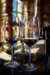 Tasting of red dry wine in Chateauneuf-du-Pape wine making village in France with green vineyards on large pebbles galets and sandstone clay soil