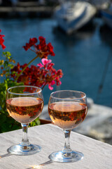 Pouring in glasses of cold rose Cote de Provence wine in yacht harbour of Port Grimaud, summer vacation on French Riviera Provence, France