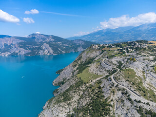 Aerial view on blue Lake of Serre-Poncon, reservoir border...