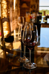 Tasting of red dry wine in Chateauneuf-du-Pape wine making village in France with green vineyards on large pebbles galets and sandstone clay soil