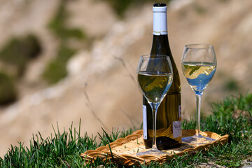 Glass and bottle of dry white Roussette de Savoie or Vin de Savoie wine from Savoy region served on Col du Galibier border Savoy region, France, view Alpes mountains