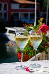 Glasses of cold white Cote de Provence wine in yacht harbour of Port Grimaud, summer vacation on French Riviera in Provence, France