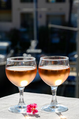Pouring in glasses of cold rose Cote de Provence wine in yacht harbour of Port Grimaud, summer vacation on French Riviera Provence, France