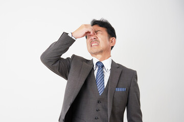 眼精疲労のミドルエイジのビジネスマン　白背景
