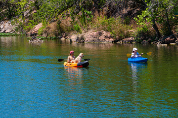 Fototapeta na wymiar Kayakers With Yellow Lab Near Devils Waterhole at Inks Lake State Park, Burnet, Texas, USA