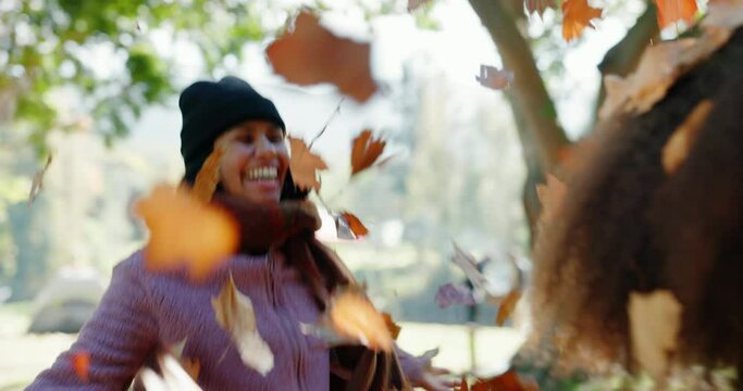 Happy, throwing leaves and friends in nature for winter, autumn or celebration together. Smile, park and excited women with plants to celebrate fall in a field for environment or season change