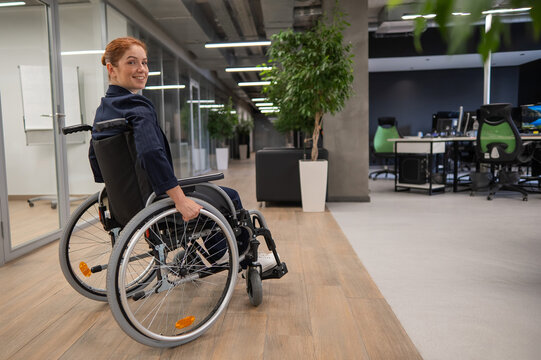 Caucasian woman wheelchair in open space office.