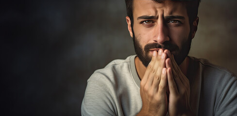 Sad man mourning on dark background. Sadness, grief and loss concept. 