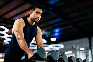 Young Asian Man Working Out with Dumbbell in a Vibrant Gym - Fitness and Wellness Concept for...